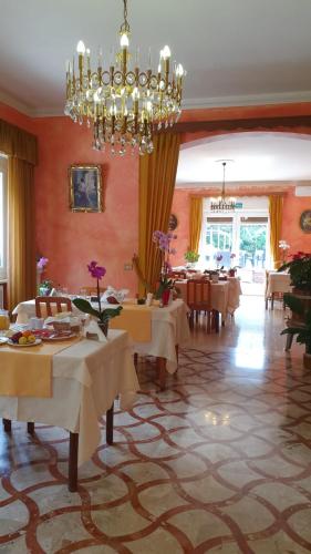 a dining room with tables and a chandelier at Apartment Lake Maggiore - Gelsomino in Maccagno Inferiore