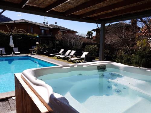 een grote hot tub naast een zwembad bij Apartment Lake Maggiore - Gelsomino in Maccagno Inferiore