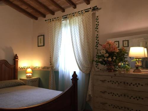 a bedroom with a bed and a window with a dresser at Casale Eredità in Orte