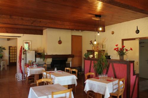 a restaurant with tables and chairs and a fireplace at Hôtel La Peupleraie in Nampont-Saint-Martin