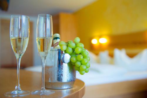 two glasses of champagne and a vase of green grapes at Familiengut Ertlhof in Seeboden