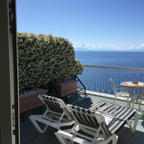 two chairs and a table on a balcony overlooking the ocean at Hotel Bellevue Suite in Amalfi