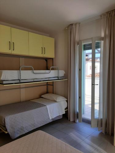 um quarto com 2 beliches e uma porta de vidro deslizante em Casa VerdeMare em Porto Recanati