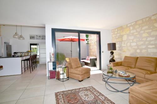 a living room with a couch and a table at Chambres à Bord'O in Bordeaux