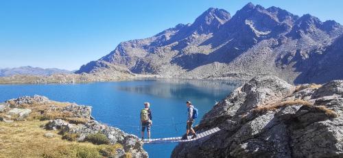two people on a rope bridge over a mountain lake at Apartments Bergblick in Sonnenalpe Nassfeld