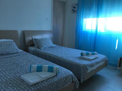 two beds in a bedroom with blue lighting at Palma Villa 14 in Protaras