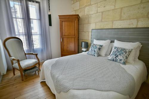 a bedroom with a large bed and a chair at Chambres à Bord'O in Bordeaux
