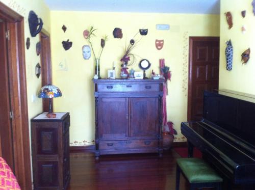 a room with a wooden cabinet and a piano at Casa das Augas Santas in Aguas Santas
