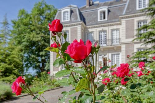 a bunch of red roses in front of a house at Château d'Avesnes - Le Castelet in Avesnes-en-Bray