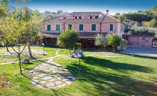 a large house with a yard with a stone path at Relais Borgofasceo in Ortovero