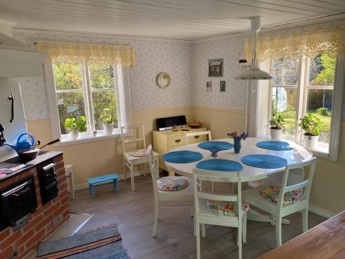 uma cozinha com mesa e cadeiras num quarto em Borgdala Stugor em Ödkarby