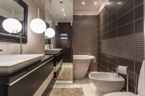 a bathroom with a sink and a toilet and a tub at Panoramic Sea Views in Klaipėda