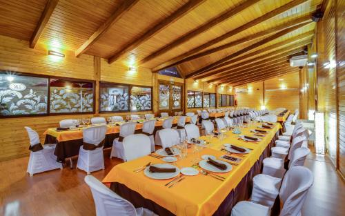 a large room with long tables and white chairs at Hotel Ciudad de Martos in Martos