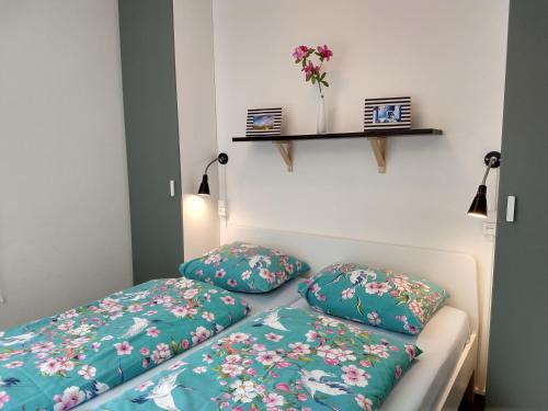 ヴェストカペレにあるPARKZICHT Bed by the Seaの花が飾られた壁の客室内のベッド2台