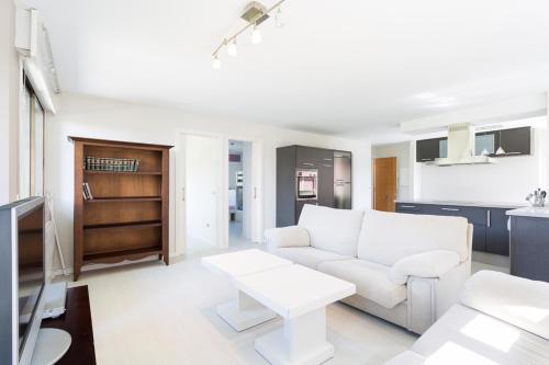 a living room with a white couch and a table at Housingcoruña Apartamento Playa Miño 03 in Miño