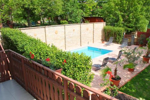a backyard with a swimming pool and a fence at Ibolya Apartmanok in Fonyód