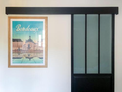a picture on a wall with a black door at Studio Nathalie et Sebastien in La Brede