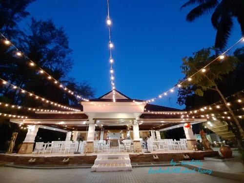 a pavilion with lights and white chairs at night at Pakmeng Resort in Pak Meng
