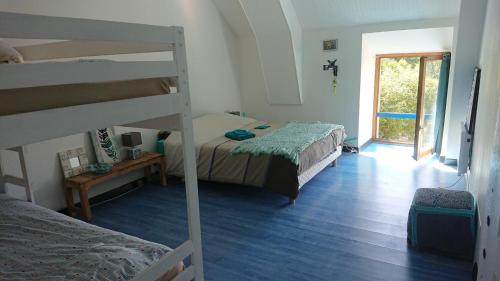 Un dormitorio con dos literas y una ventana. en Les Floralis, en La Grée-Saint-Laurent