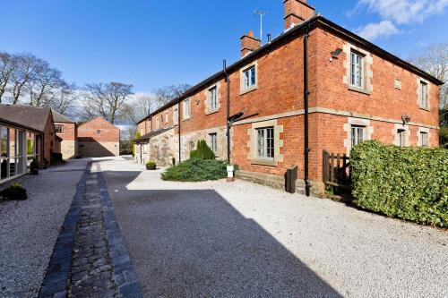 a large brick building with a road in front of it at Knockerdown Cottages in Ashbourne