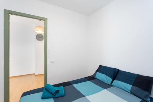 a bedroom with a blue bed with a mirror at Flat near the beach and center of Tossa de Mar "Sol" in Tossa de Mar