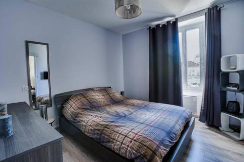 Schlafzimmer mit einem Bett und einem Fenster in der Unterkunft Appartement T3 classé***centre ville in Périgueux