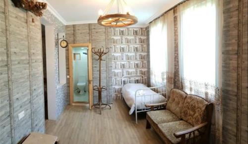 a bedroom with a bed and a couch and a window at Guest House Shvelidze in Borjomi