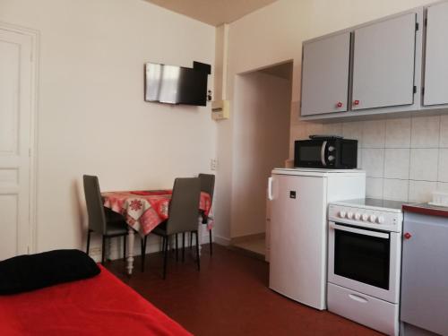 eine kleine Küche mit einem Tisch und einer Mikrowelle in der Unterkunft Appartement Le Cernuschi 2C in Menton