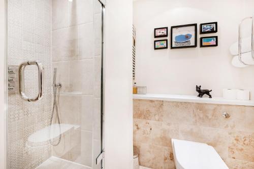 a bathroom with a shower and a toilet and a sink at Notting Hill Gardens Apartments in London