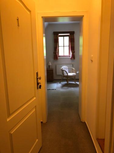 an open door to a hallway with a chair in a room at Malá Svatá Hora - penzion & restaurace in Mníšek pod Brdy