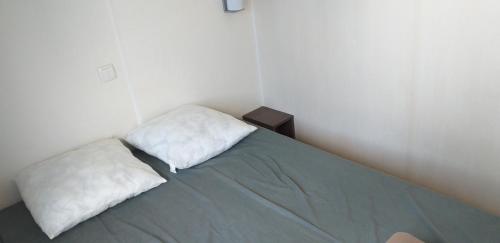 une chambre avec un lit avec deux oreillers dessus dans l'établissement mobil-home camping 4 ****, à Vic-la-Gardiole