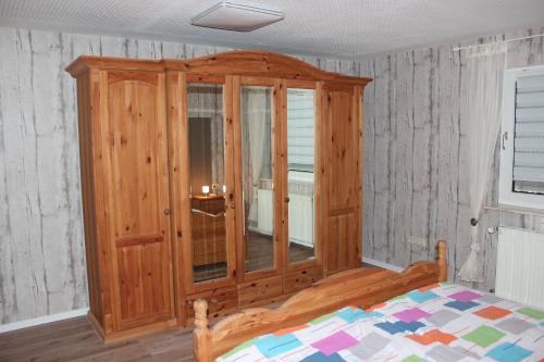 a bedroom with a wooden cabinet and a bed at fewogriebelschied in Griebelschied