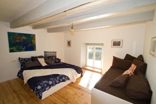1 dormitorio con 2 camas y sofá en Au grain de Celles, en Celles-en-Bassigny