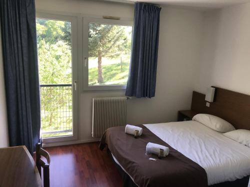 a hotel room with two beds and a window at Hôtel Restaurant L'Artière in Ceyrat