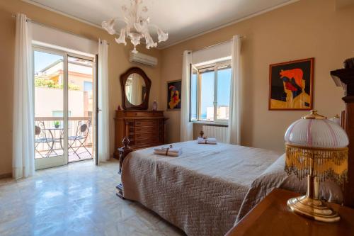 een slaapkamer met een groot bed en een spiegel bij Appartamento d'autore in Capo dʼOrlando