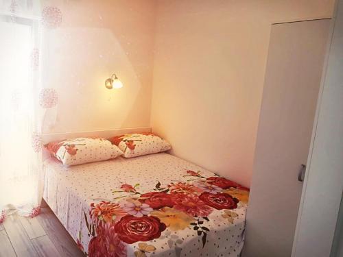 a small bedroom with a bed with flowers on it at House GITA in Mrljane