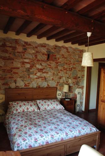 um quarto com uma cama e uma parede de pedra em Podere San Paolo em San Giuliano Terme