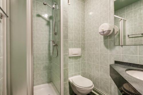 uma casa de banho com um chuveiro, um WC e um lavatório. em Hôtel Siatel Besançon Chateaufarine em Besançon