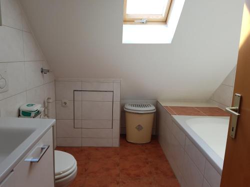 a bathroom with a toilet and a sink and a window at Green Hill Apartments - Feldkirch in Feldkirch