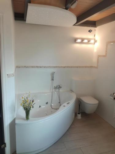 a white bathroom with a tub and a toilet at Marinapark Scharmützelsee in Wendisch Rietz