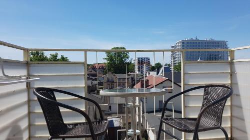 d'une terrasse avec 2 chaises et une table sur un balcon. dans l'établissement DAVIO dla 2 osób, à Międzyzdroje