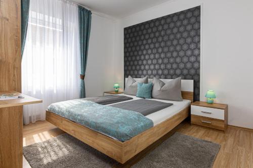 a bedroom with a large bed with a black headboard at Kőszeg Panzió in Kőszeg