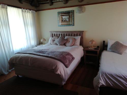 a bedroom with two beds with a naked person laying on the bed at A Swallows Rest in Kareedouw