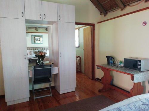 a room with a kitchen and a table with a microwave at A Swallows Rest in Kareedouw