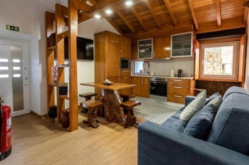 a living room with a blue couch and a kitchen at Casa Largo S Lourenço e Casa da Videira in Mazes
