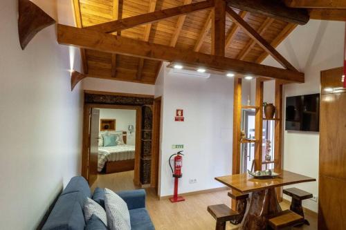 a living room with a blue couch and a bedroom at Casa Largo S Lourenço e Casa da Videira 