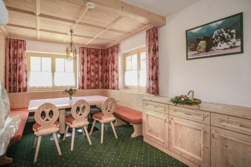une salle à manger avec une table et quatre chaises dans l'établissement Hotel Silbertal - Almhütten, à Sölden