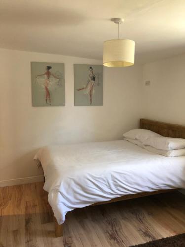 um quarto com uma cama com duas fotografias na parede em The Barn em Wyboston