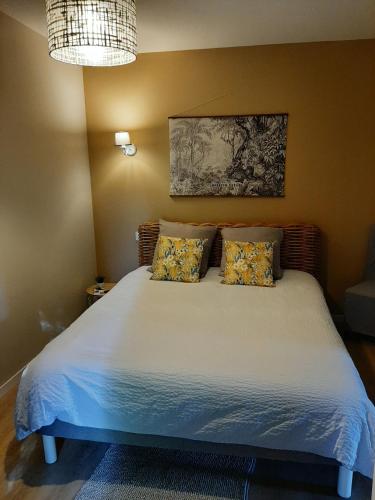 une chambre avec un lit blanc avec deux oreillers dans l'établissement La Villa Claudia, à Pennautier