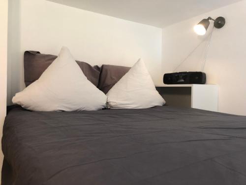 łóżko z dwoma białymi poduszkami na górze w obiekcie Loft mon Soleil w mieście Le Hohwald